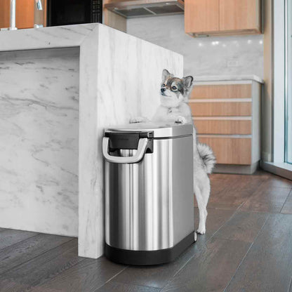 Simplehuman Medium Pet Food Can, Brushed Stainless Steel, lifestyle view with dog, secure airtight locking handle, easy-move wheels.