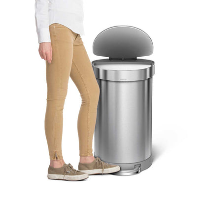 Lifestyle shot of Simplehuman 45L Semi-Round Step Can, Brushed Steel, showing hands-free pedal use and liner rim.