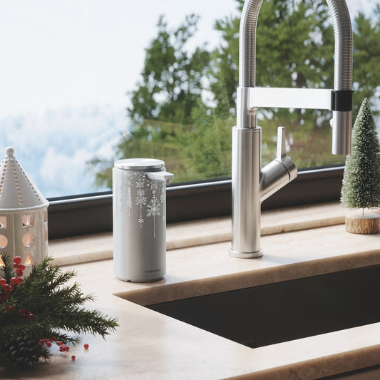 Simplehuman 14 oz. Sensor Pump with silver Holiday Sleeve in festive kitchen setting, touch-free operation.