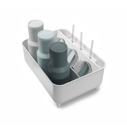 Angled view of Simplehuman White Bottle Dock holding 3 reusable bottles in assorted colors with straws and lids.